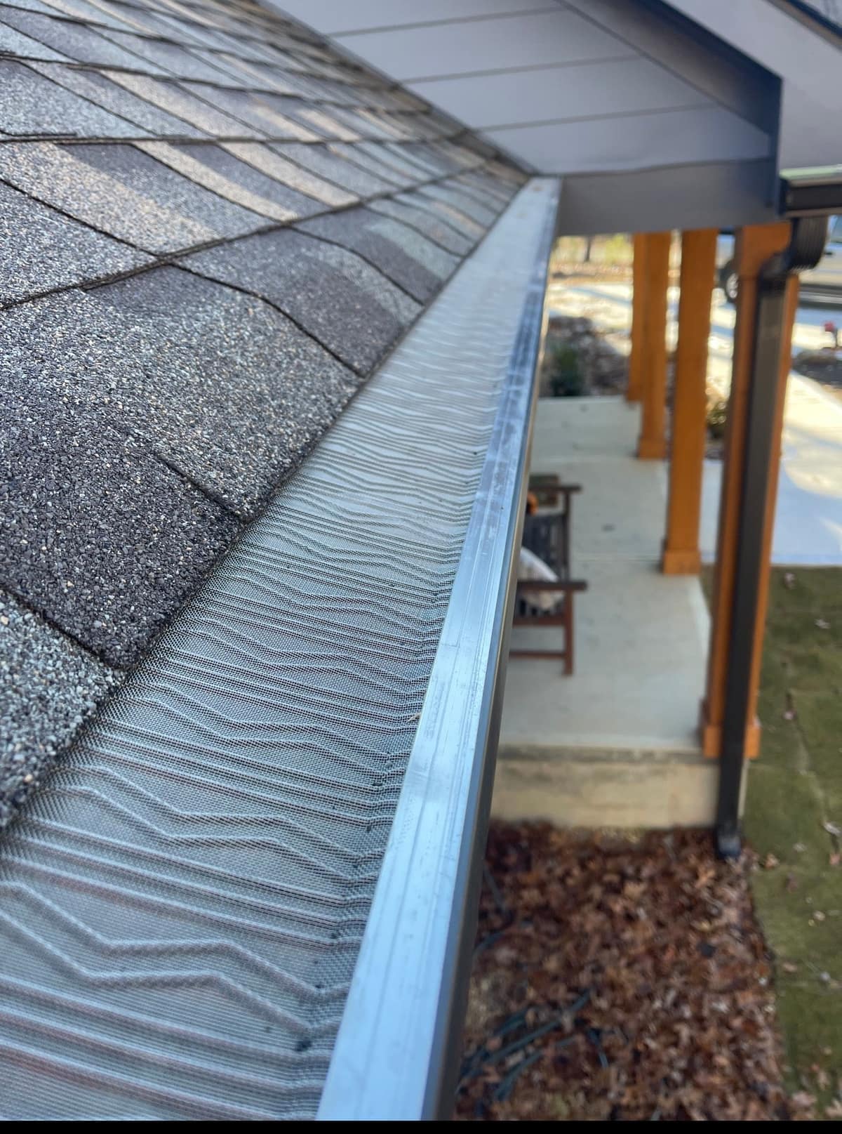 Stainless steel micro-mesh gutter guard screwed onto a gutter run