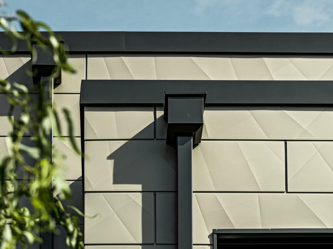 Plain square downpipe sections fitted together against a house wall